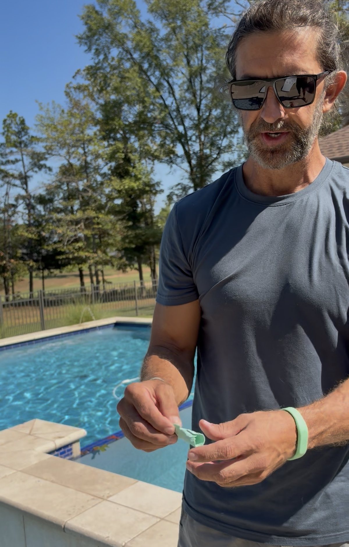 Matt Phillips holding a broken rubber bubbler tube during a pool inspection