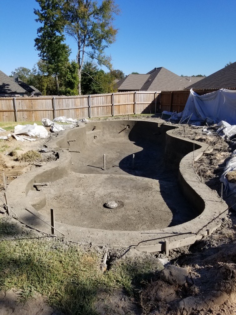 Gunite pool shell under construction showing residential pool depth and floor geometry
