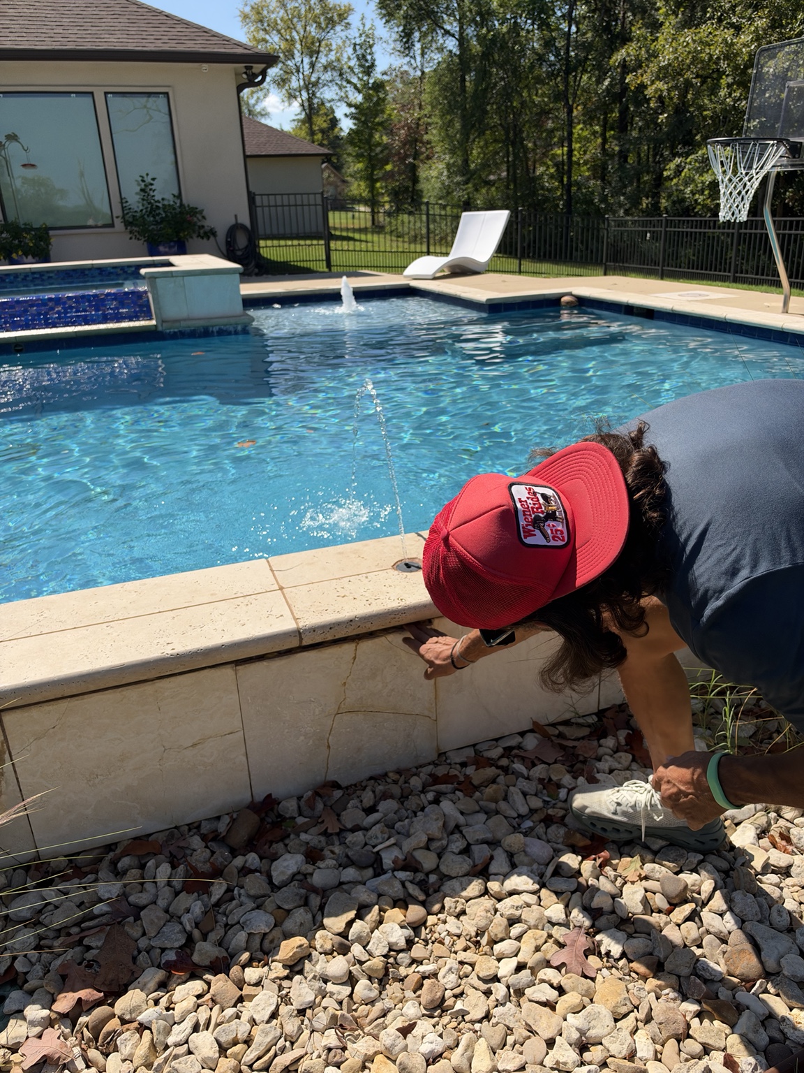 Matt Phillips examining swimming pool coping and the pool perimeter