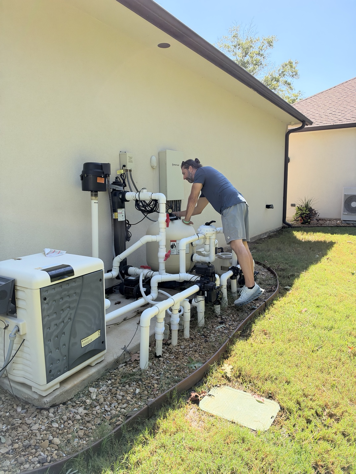 Matt Phillips inspecting swimming pool pumps filters heater and equipment